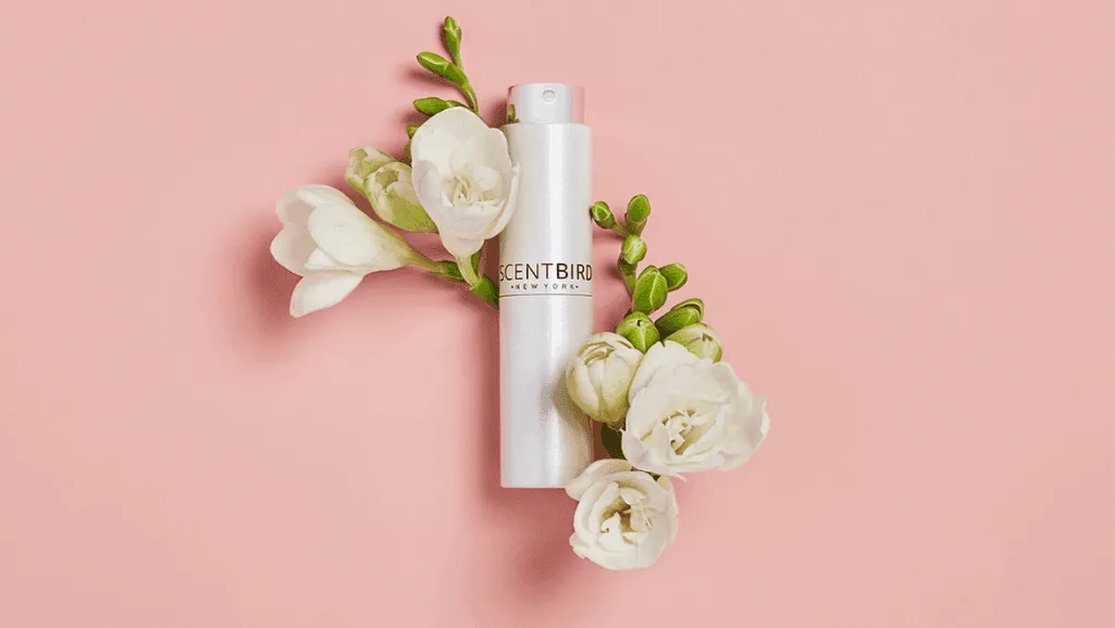Perfume bottles with freesia fragrance notes surrounded by fresh freesia flowers